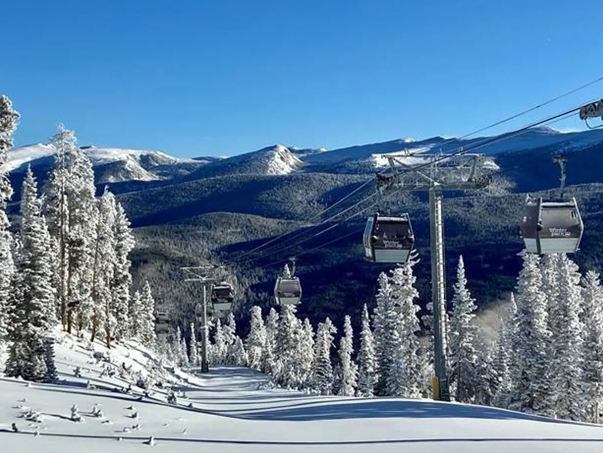 This image captures ski lift gondolas gliding over a snow-covered landscape, framed by distant mountains. The setting exudes a sense of adventure and alpine excitement, perfectly reflecting the proximity of Chalet 1415 to Winter Park Resort and the winter sports available nearby.